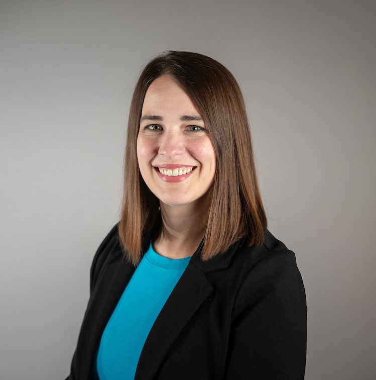 woman with brown hair, blue shirt, and black blazer
